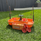 Jeu de pêche pour enfants sur gazon, avec cannes à pêche, poissons en plastique et palmier. Jouet éducatif extérieur, activité ludique.
