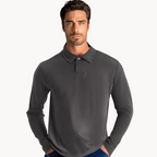 Homme portant un polo gris à manches longues, col boutonné, sur fond blanc. Mode masculine élégante, tenue décontractée chic.