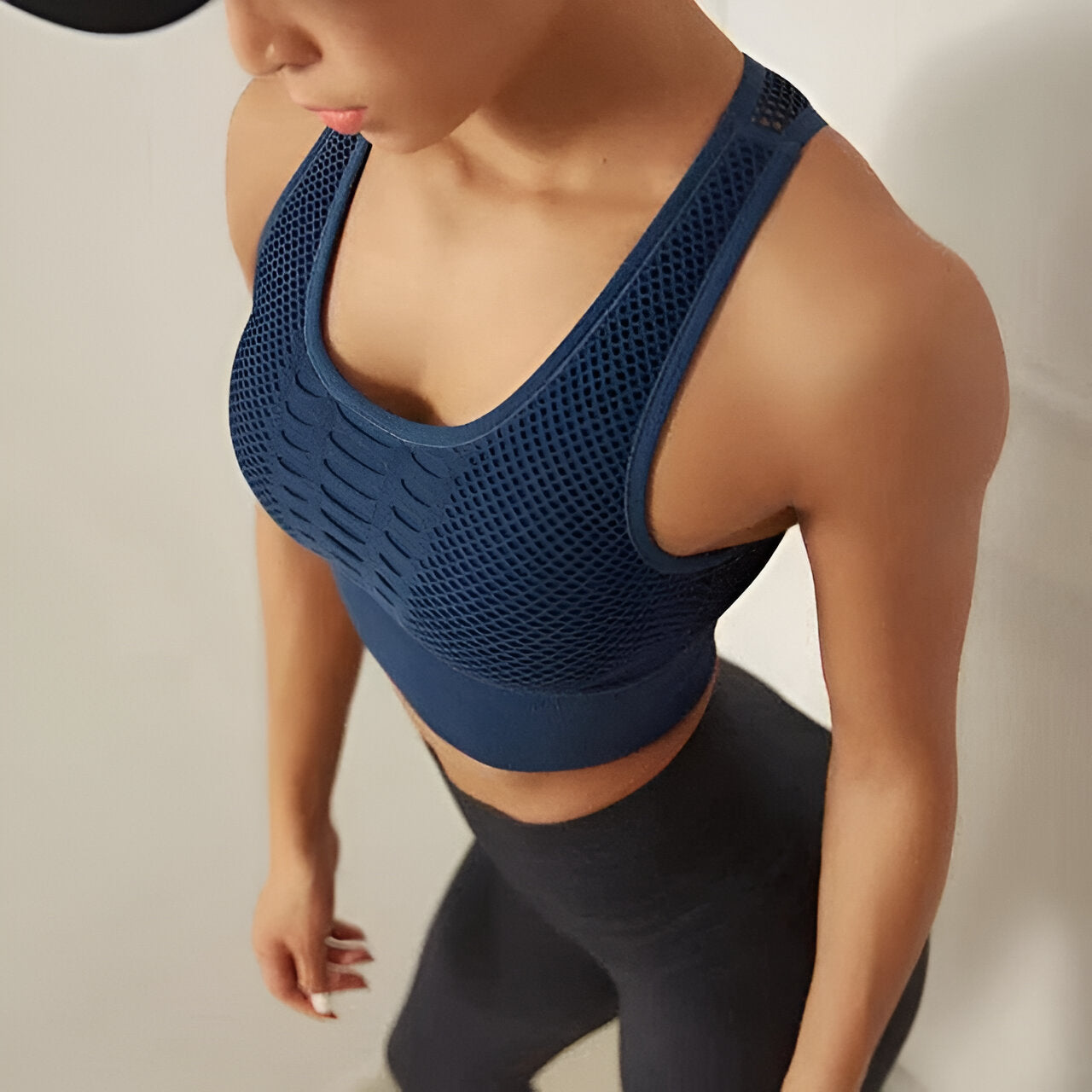 Femme en tenue de sport, brassière bleue et leggings noirs, vue de haut. Fitness, mode active, vêtements de sport pour femme.
