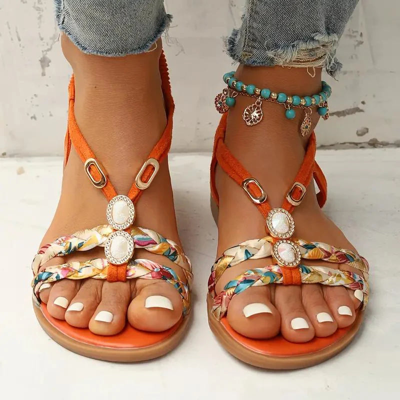 Sandales d'été colorées avec ornements, portées avec un jean déchiré et bracelet de cheville turquoise. Mode féminine, chaussures tendance.