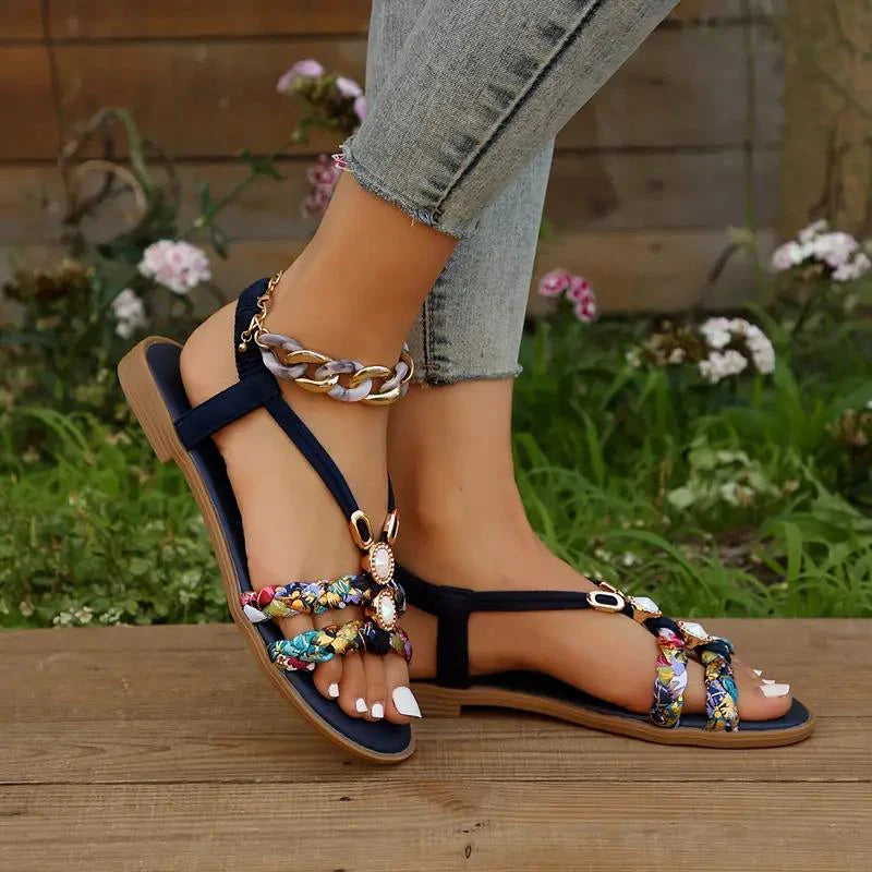 Sandales d'été colorées pour femme avec motifs floraux, bracelet chaîne dorée, portées avec un jean. Chaussures tendance pour la saison estivale.