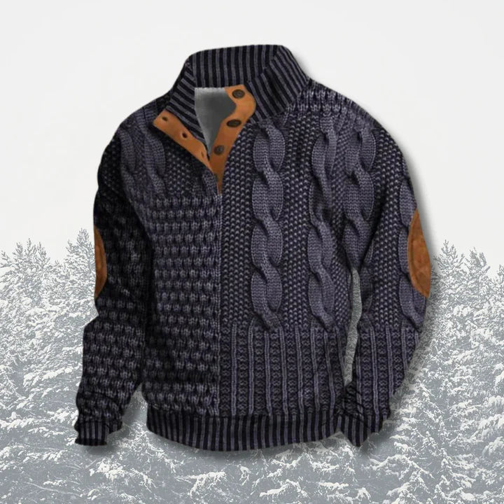 Pull en laine torsadée bleu marine avec coudières en cuir marron, col montant et boutons en bois, sur fond de forêt enneigée. Mode hiver élégante.
