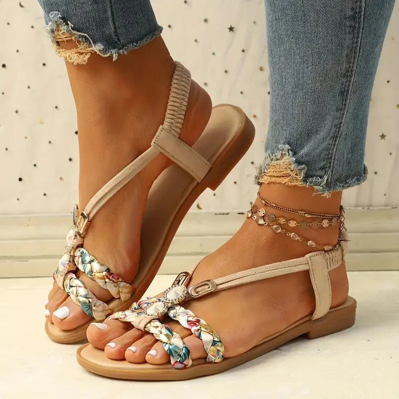 Sandales d'été tressées multicolores pour femme, portées avec un jean déchiré. Chaussures plates élégantes, parfaites pour la mode estivale.