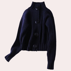 Gilet en maille noir à gros boutons, col montant, manches longues, style tendance automne-hiver, mode féminine élégante et confortable.