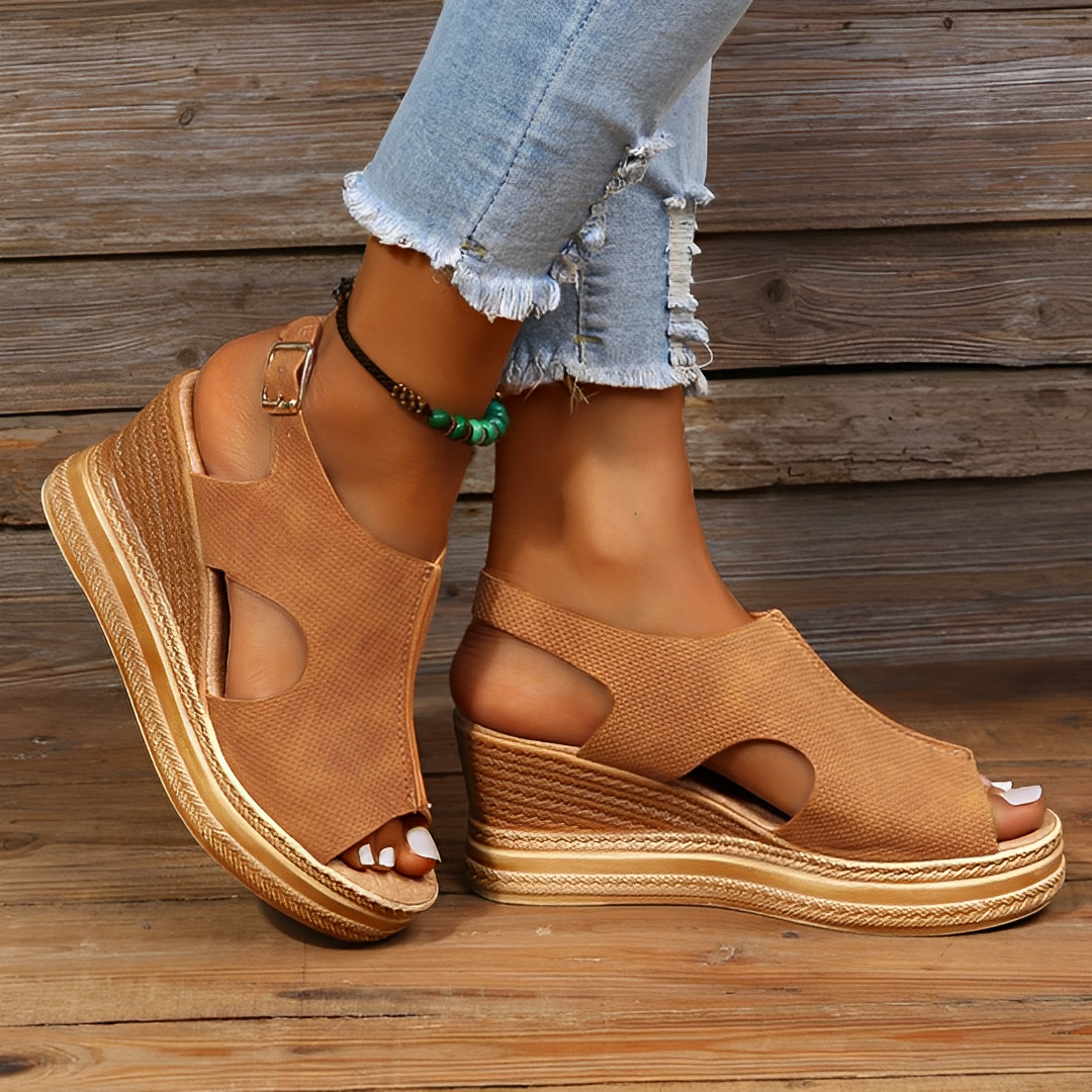 Sandales compensées marron en cuir texturé, portées avec un jean déchiré. Chaussures d'été tendance, idéales pour un look décontracté et élégant.