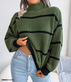 Femme portant un pull vert à col roulé et rayures noires, associé à un jean bleu clair. Mode automne-hiver, style décontracté et tendance.