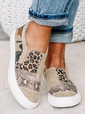 Chaussures slip-on femme avec motifs léopard et camouflage, semelle blanche épaisse, portées avec un jean retroussé. Mode décontractée tendance.