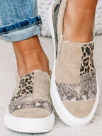 Chaussures slip-on en toile à motifs léopard et serpent, portées avec un jean retroussé. Style décontracté, tendance et moderne.