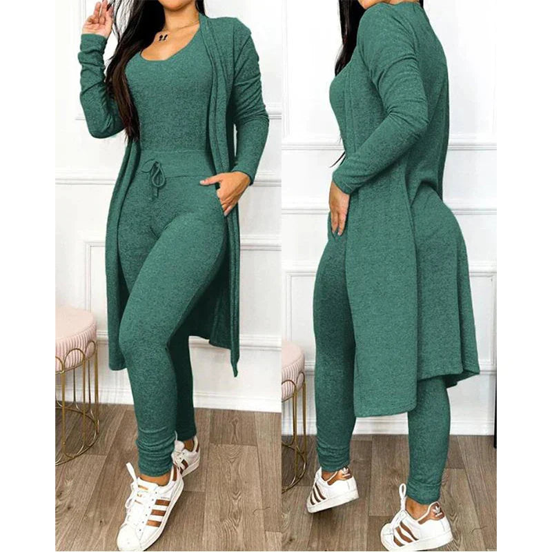 Tenue femme verte élégante, ensemble cardigan long et combinaison ajustée, style décontracté chic, baskets blanches, mode automne-hiver tendance.