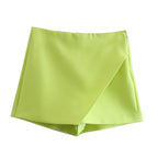 Short vert citron pour femme, design asymétrique, tissu léger et moderne. Mode estivale tendance, vêtement féminin élégant et confortable.