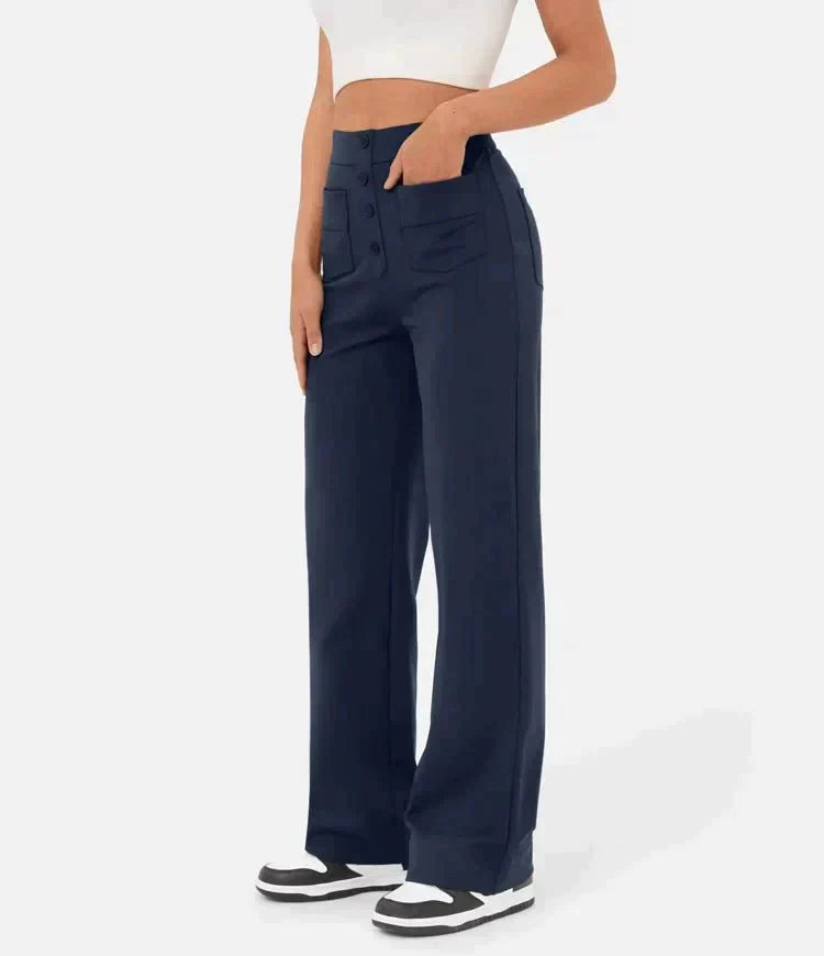 Pantalon large bleu marine pour femme, taille haute, avec poches avant, porté avec un haut blanc. Mode élégante et décontractée.