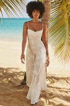 Femme en robe blanche élégante sur plage tropicale, marchant sous palmiers avec mer turquoise en arrière-plan. Mode estivale, vacances exotiques.