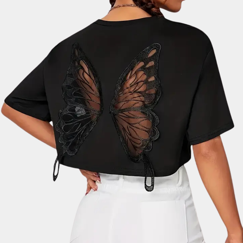 Femme portant un t-shirt noir avec motif ailes de papillon en dentelle transparente à l'arrière, mode tendance, style décontracté.