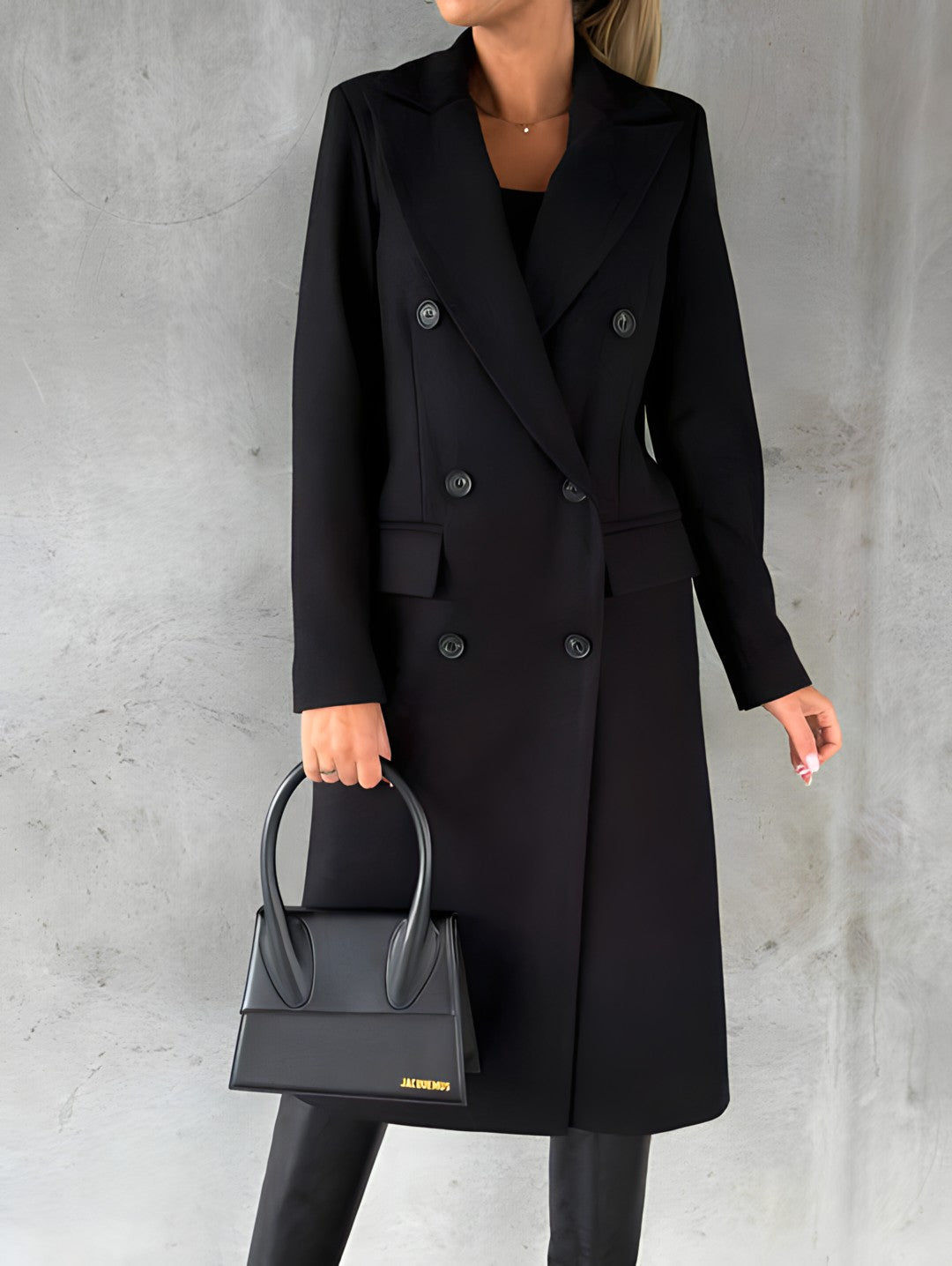 Femme en manteau noir élégant, tenant un sac à main noir moderne. Mode automne-hiver, style chic et sophistiqué, tendance vestimentaire féminine.