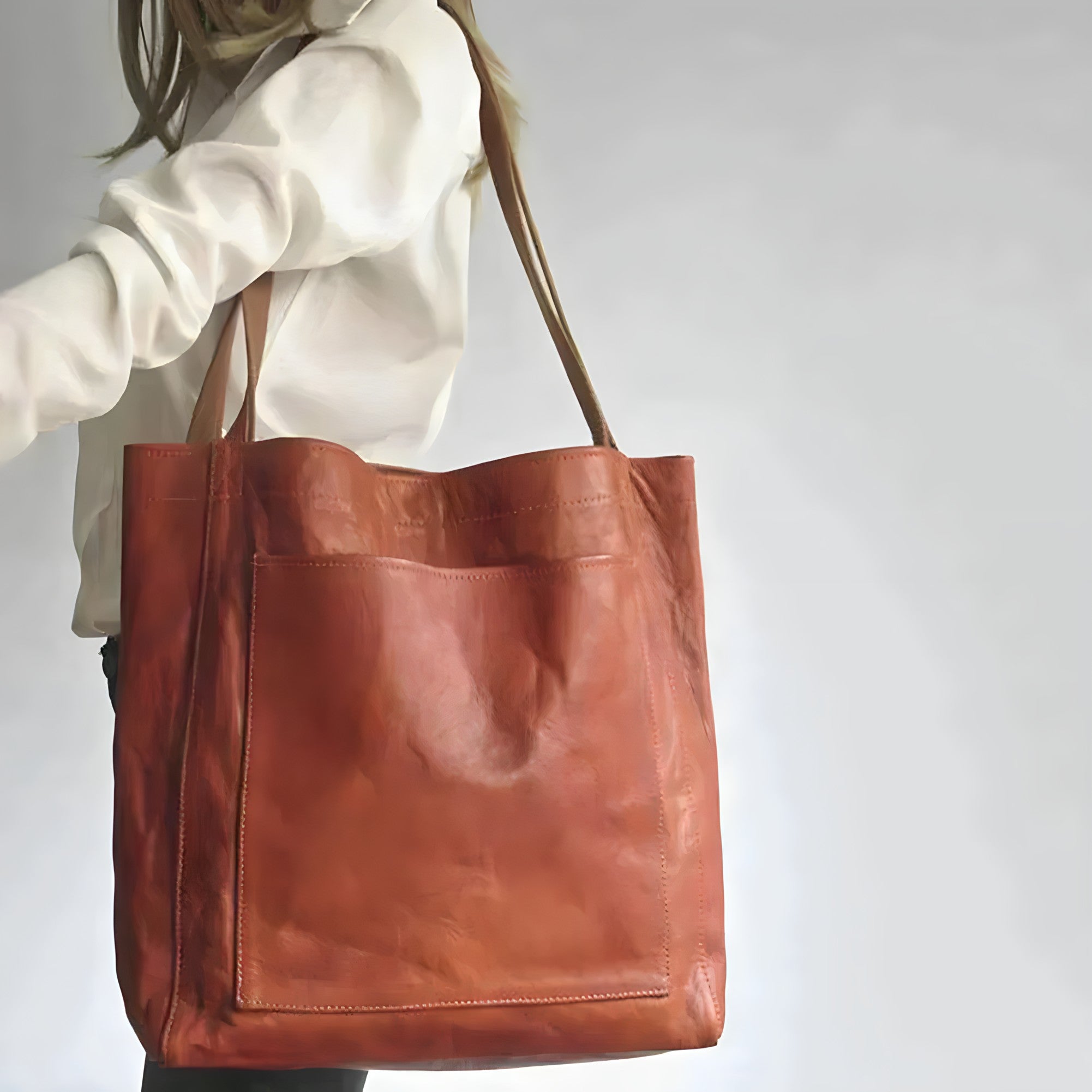 Sac en cuir marron porté par une femme en chemise blanche, design élégant et moderne, accessoire mode tendance, idéal pour le quotidien.