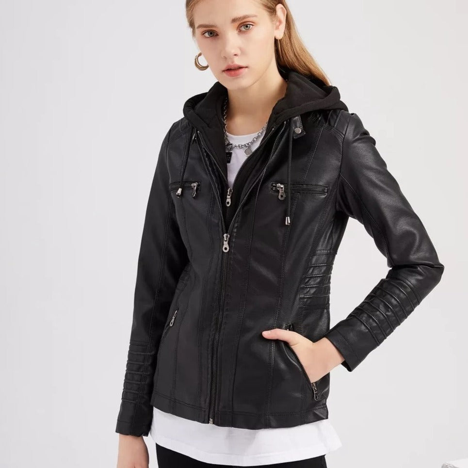 Jeune femme portant une veste en cuir noir avec capuche, fermetures éclair argentées et détails matelassés, style moderne et tendance.