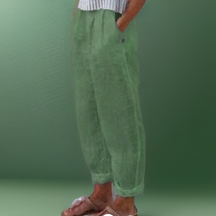 Pantalon vert en lin pour femme, coupe ample, avec poches latérales, porté avec un haut rayé. Mode décontractée, tendance été.