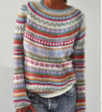 Pull en laine multicolore à motifs géométriques, manches longues, porté avec un jean décontracté. Mode automne-hiver, style bohème chic.