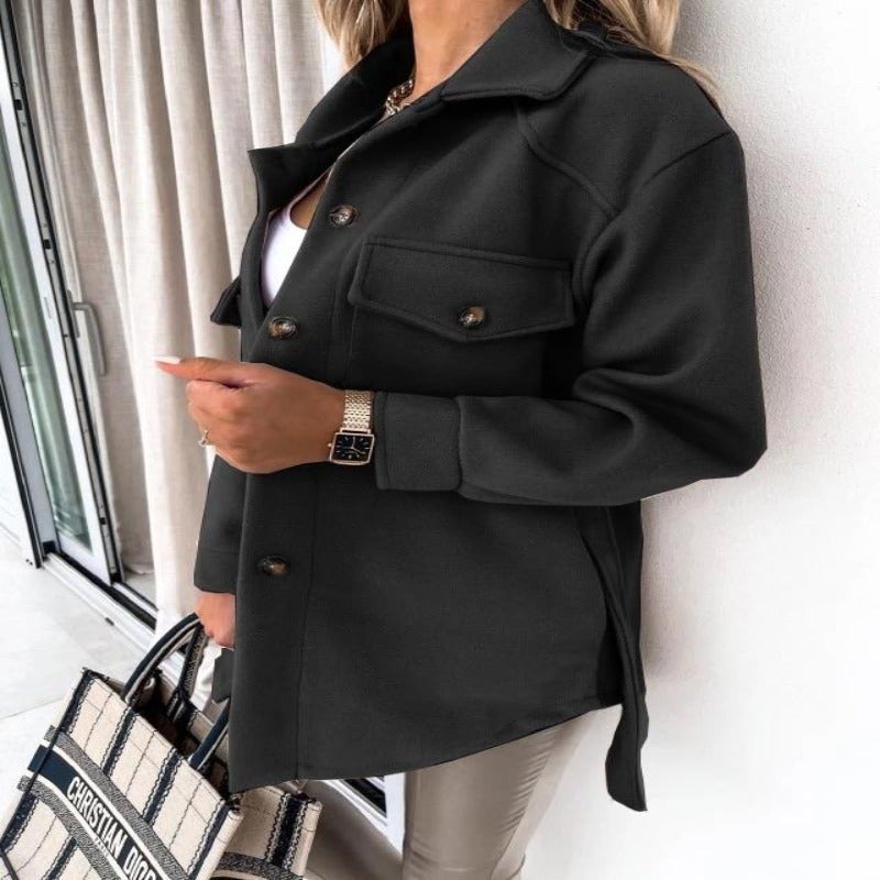 Femme portant une surchemise noire élégante avec boutons, montre dorée, sac à main Dior, posant près d'une fenêtre. Mode automne chic.