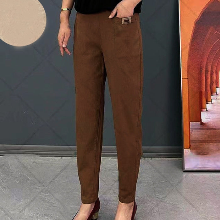 Pantalon marron élégant pour femme, coupe ajustée, porté avec des talons rouges. Mode féminine chic, tendance automne, style décontracté.