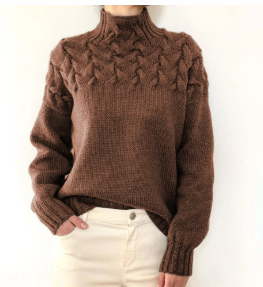 Pull en laine marron avec motif torsadé, col montant, manches longues, porté avec un pantalon blanc. Mode automne-hiver, style décontracté et élégant.