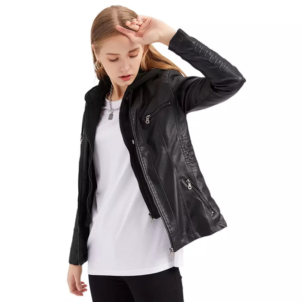 Jeune femme portant un blouson en cuir noir, t-shirt blanc et pantalon noir, posant avec élégance. Mode féminine, style urbain, tendance automne.