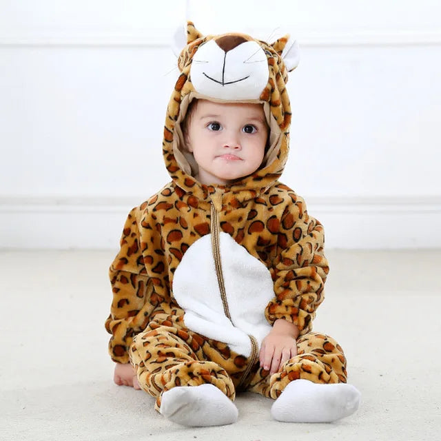 Enfant en costume de léopard assis sur le sol, pyjama animalier mignon, déguisement bébé, fond blanc, tenue confortable et douce.