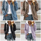 Femme portant un sweat à capuche en polaire, disponible en bleu, marron, noir et violet, avec un t-shirt blanc et un jean, tenant un café.