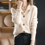 Femme portant un cardigan en laine beige avec boutons, col ouvert, manches longues, associée à un jean noir. Mode automne-hiver élégante et confortable.