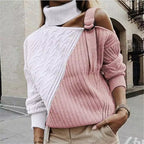 Femme portant un pull asymétrique rose et blanc à col roulé, manches longues, style urbain chic, mode automne-hiver tendance.