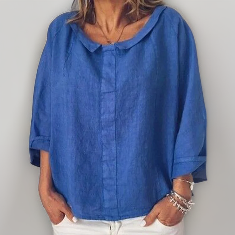 Blouse en lin bleu pour femme, manches trois-quarts, col rond, portée avec un pantalon blanc. Mode décontractée, tendance printemps-été.