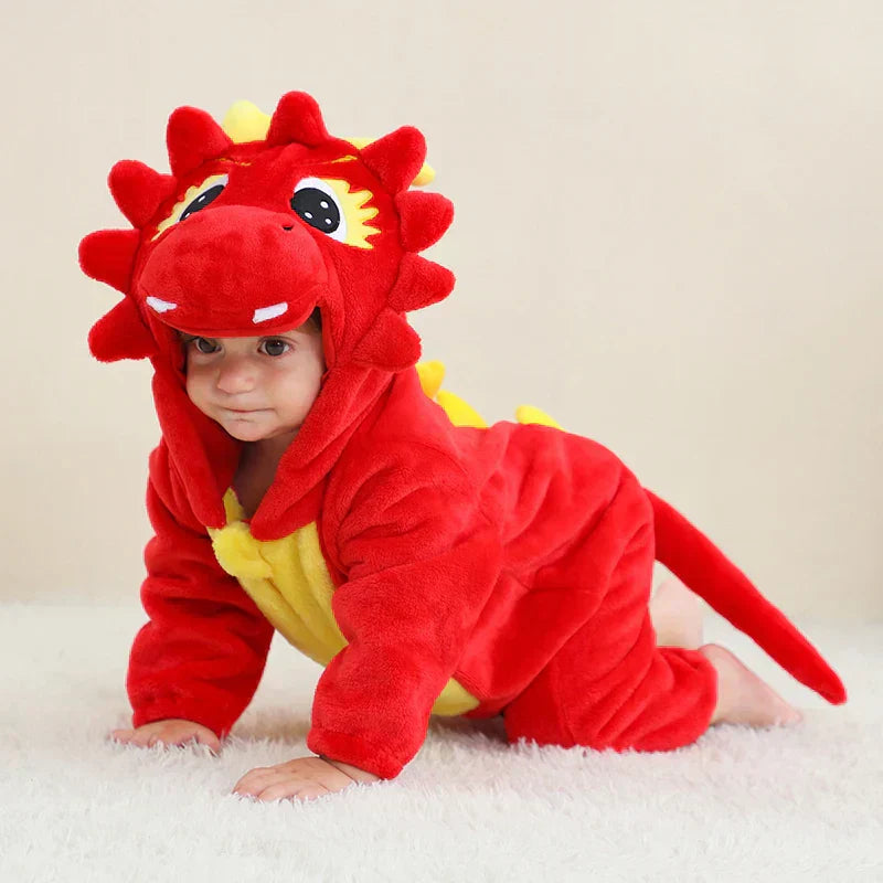 Bébé en costume de dinosaure rouge et jaune, rampant sur un tapis blanc. Tenue mignonne, déguisement enfant, photographie studio.