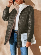 Femme portant une doudoune noire, pull blanc à col roulé, jeans, lunettes de soleil, tenant une photo. Mode automne-hiver, style décontracté.