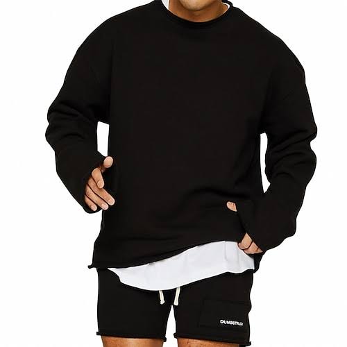 Homme portant un sweat noir ample et un short noir, style décontracté. Mode masculine, tenue sportive, vêtements tendance.