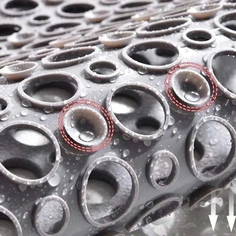 Surface en caoutchouc antidérapante avec motifs circulaires et gouttelettes d'eau, idéale pour sécurité et adhérence. Design innovant et fonctionnel.