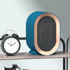 Chauffage d'appoint électrique bleu sur étagère, design moderne, à côté d'un réveil noir. Idéal pour bureau ou chambre. Économie d'énergie.
