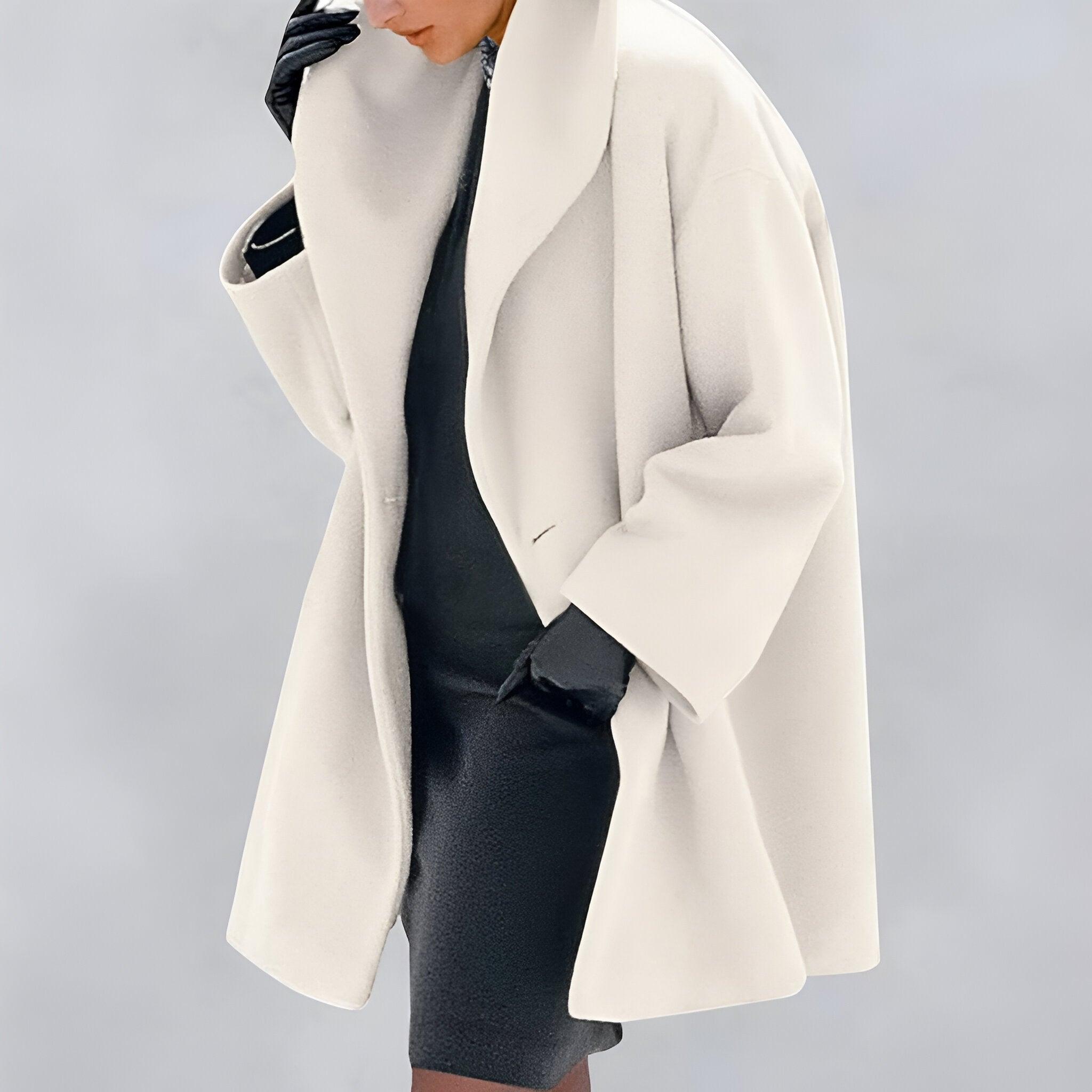 Manteau oversize blanc élégant, porté avec robe noire et gants en cuir. Mode automne-hiver, style chic et moderne.