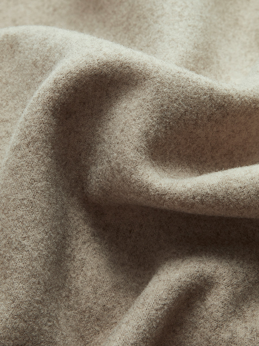 Tissu en laine beige texturé, doux et ondulé, idéal pour vêtements d'hiver, couture et décoration intérieure. Texture chaude et élégante.