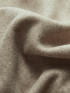 Tissu en laine beige texturé, doux et ondulé, idéal pour vêtements d'hiver, couture et décoration intérieure. Texture chaude et élégante.