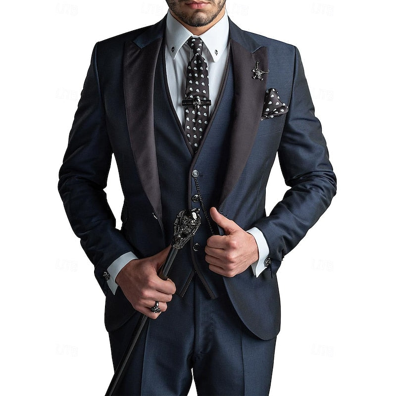 Homme en costume bleu marine élégant avec cravate à pois, tenant une canne noire ornée. Mode masculine, style sophistiqué, accessoires chics.