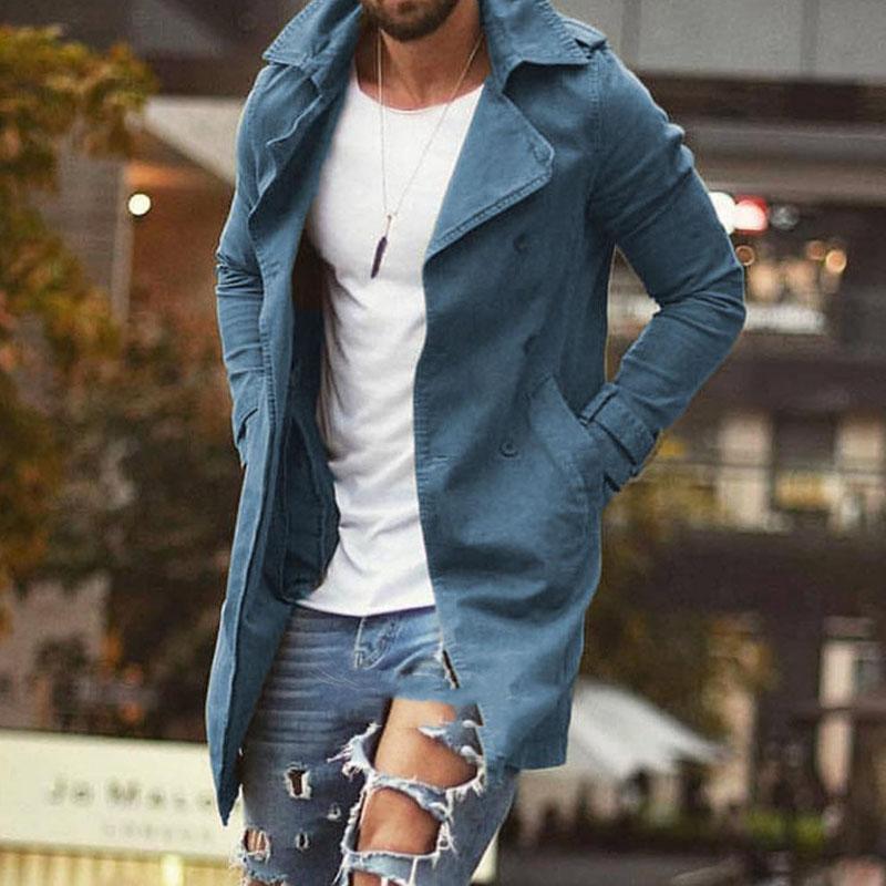 Homme en trench-coat bleu, t-shirt blanc et jeans déchirés, marchant en ville. Mode masculine, style urbain, vêtements tendance.