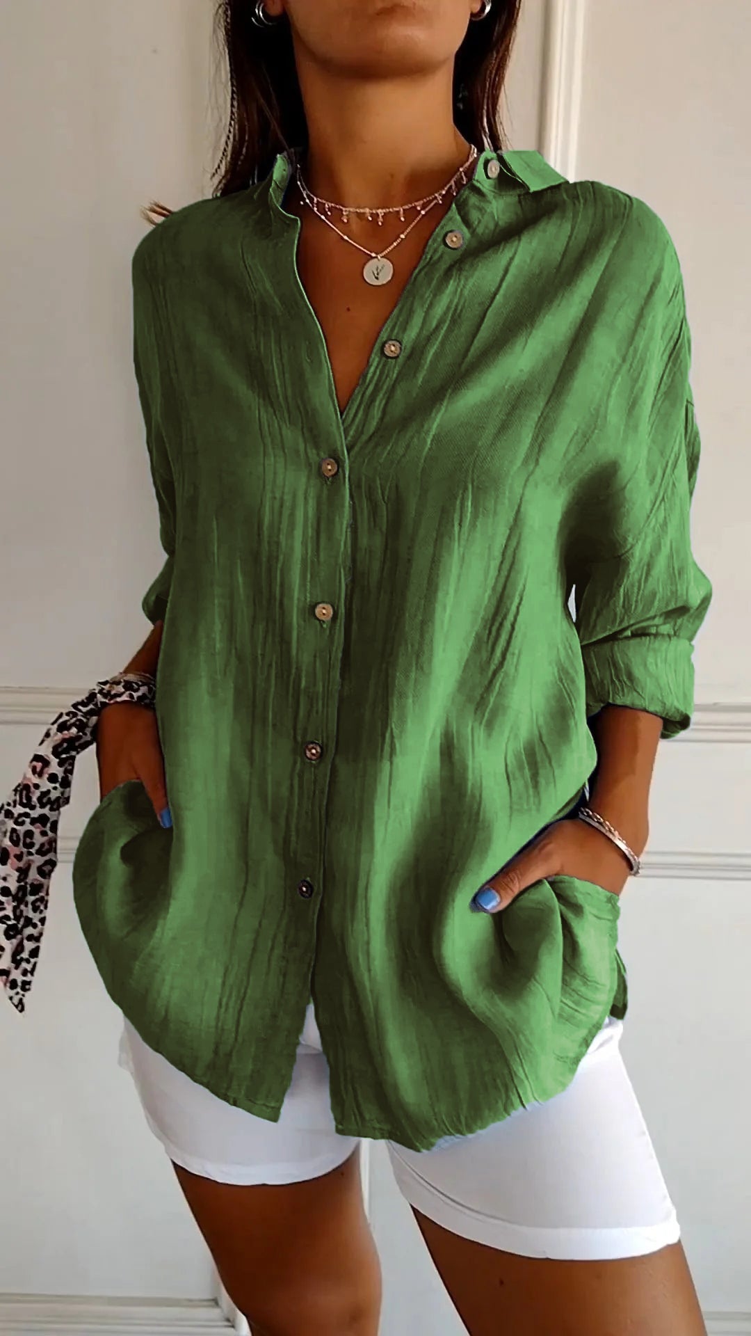 Chemise verte en lin pour femme, manches longues, boutons en bois, associée à un pantalon blanc. Mode élégante et décontractée.