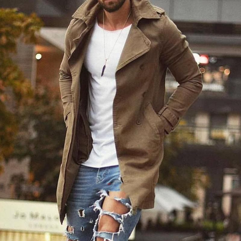 Homme en manteau beige, t-shirt blanc et jeans déchirés, marchant en ville. Mode masculine, style urbain, tendance automne.