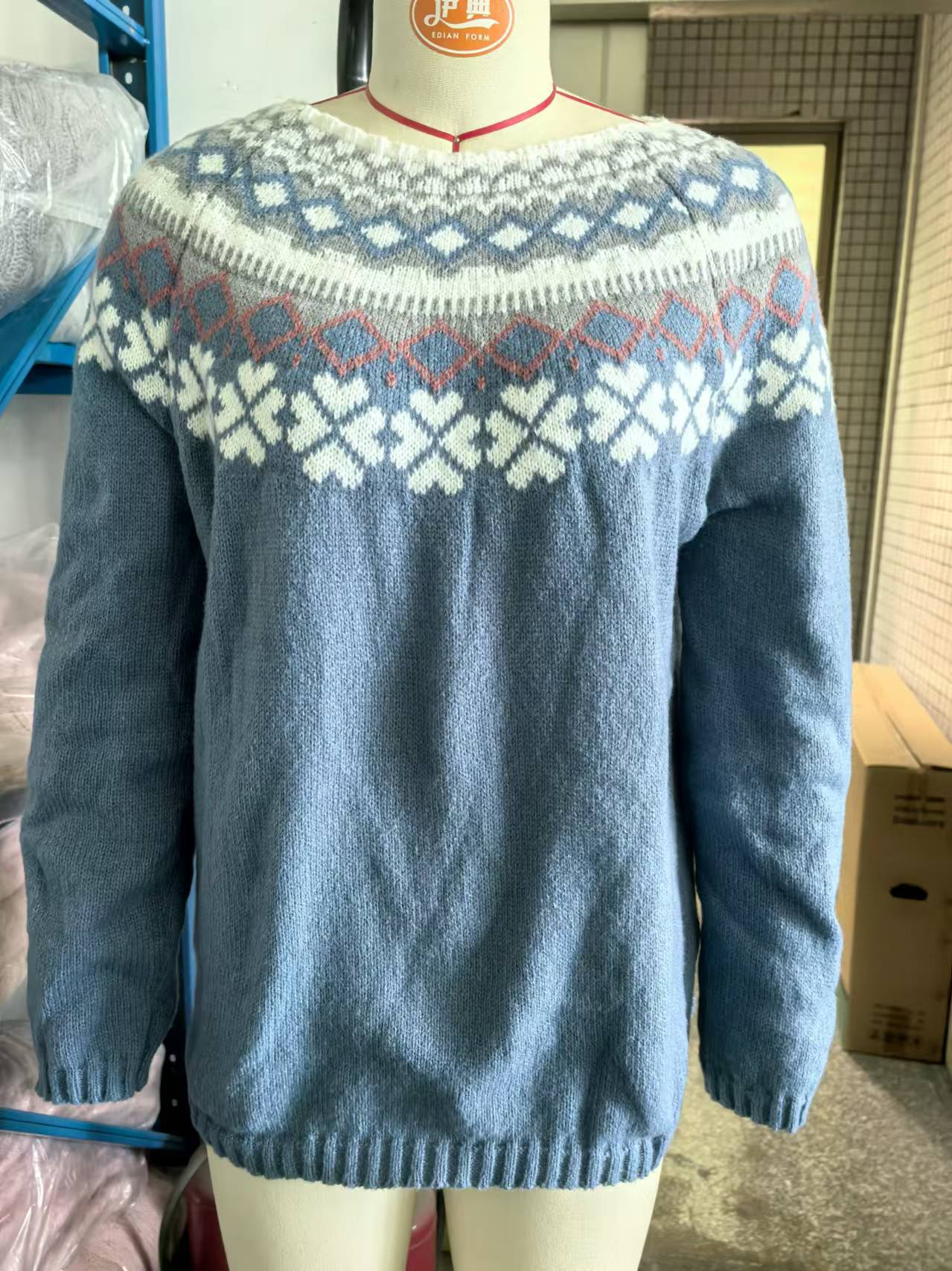 Pull bleu en laine avec motif jacquard nordique blanc et rouge, manches longues, col rond. Mode hiver, tricot chaud, style scandinave.