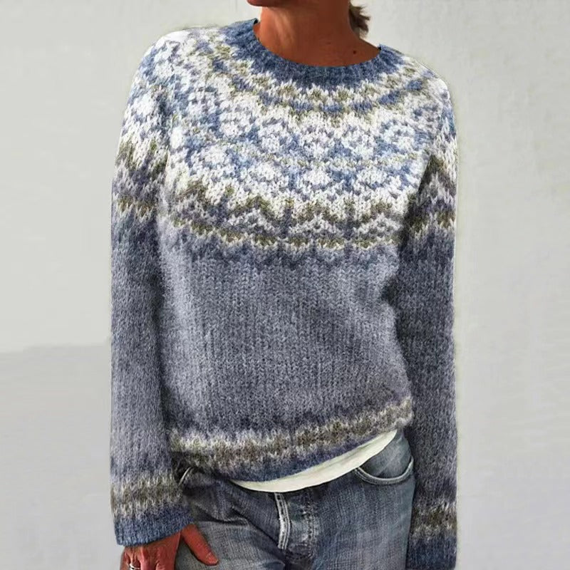 Pull en laine bleu avec motif jacquard nordique, manches longues, col rond, porté par une personne. Style décontracté et tendance automne-hiver.
