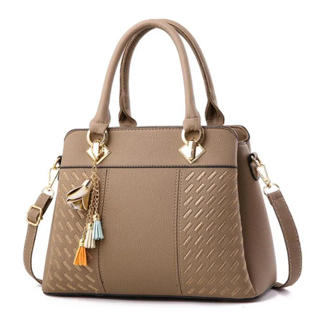 Sac à main en cuir beige élégant avec breloques colorées, bandoulière ajustable et détails dorés, parfait pour un style chic et moderne.