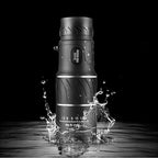 Monoculaire étanche noir, résistant à l'eau, avec zoom 16x52, idéal pour observation de jour et de nuit, éclaboussures d'eau visibles.