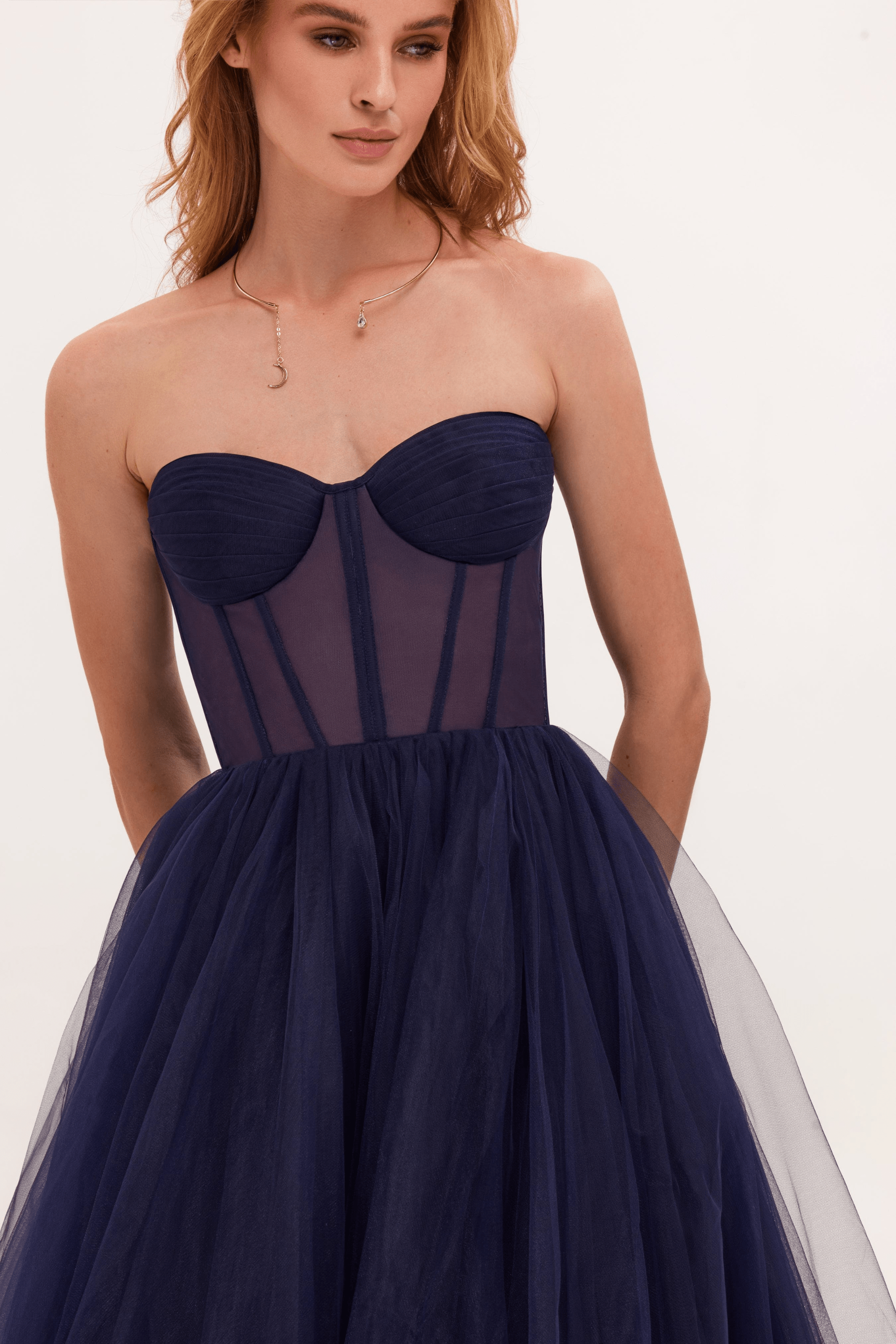 Robe bustier bleu marine en tulle, élégante et moderne, portée par une femme. Mode féminine, tenue de soirée chic, style glamour.