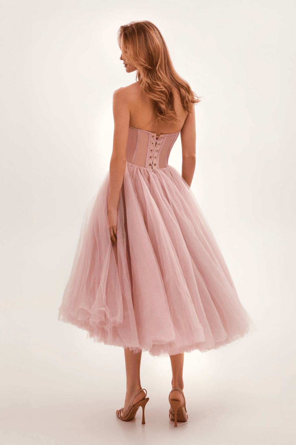 Robe de bal rose en tulle avec corset lacé, vue de dos. Élégante et féminine, idéale pour soirées et événements spéciaux.