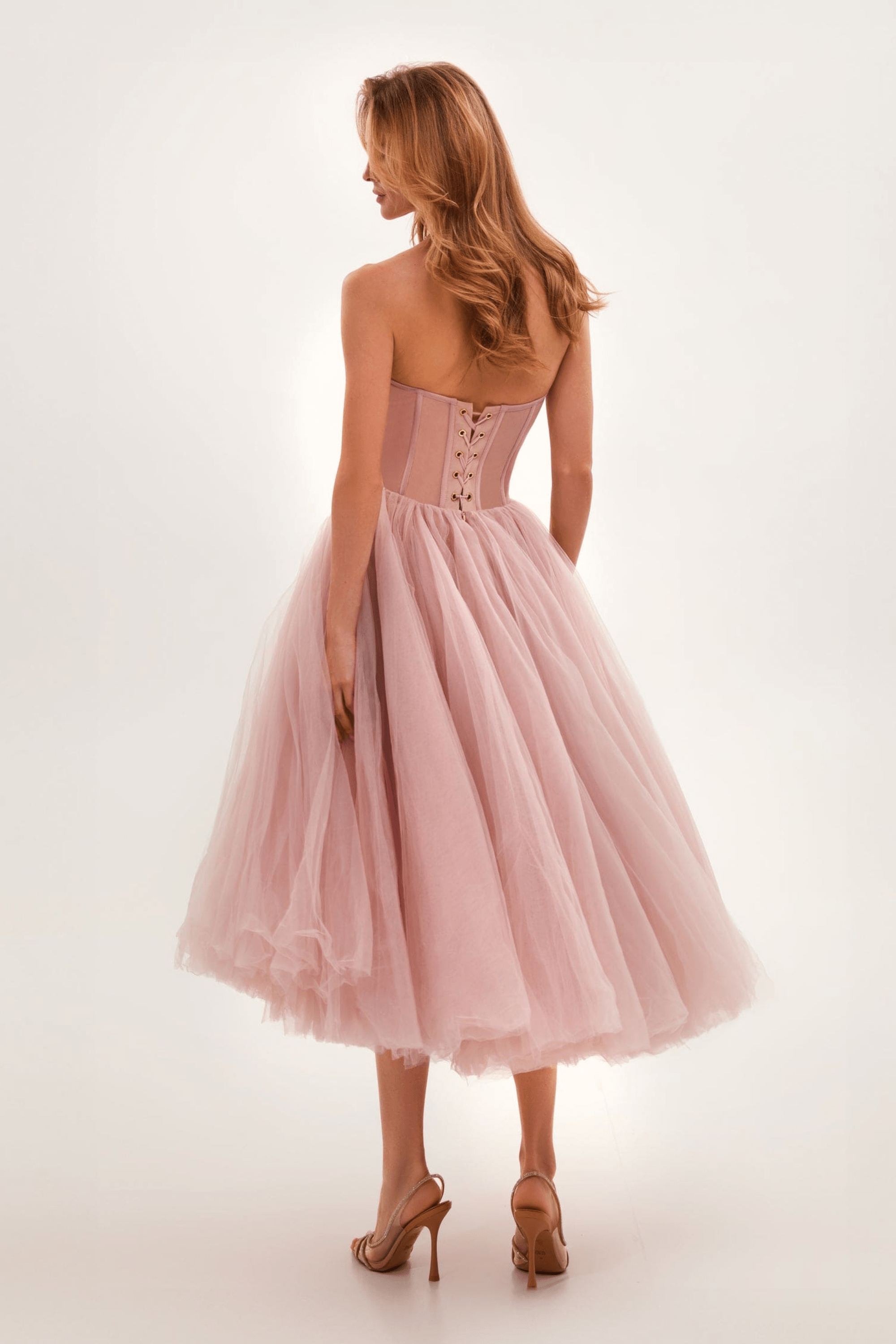 Robe de bal rose en tulle avec corset lacé, vue de dos. Élégante et féminine, idéale pour soirées et événements spéciaux.